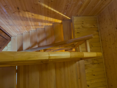 Internal straight wooden stairs of the building with handrails, top view of the stair case with several flights and landings on several floorsの写真素材