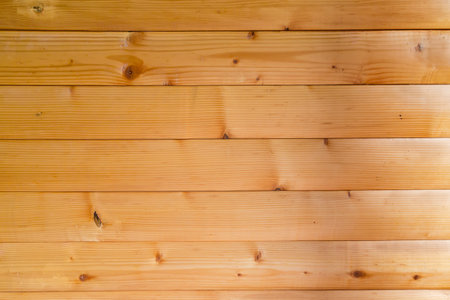 Part of the wall lined with horizontal varnished wooden beams, made with softwood indoors, texture, background,の写真素材