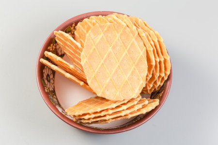 Sweet round thin flat crisp wafers in the small clay bowl on a gray background, top viewの写真素材