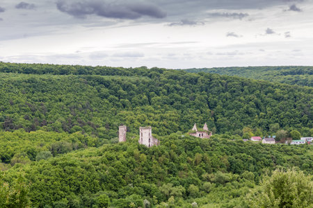 Ruins of ancient castle in center of bowl-shaped deepening in Dzhuryn River valley in spring overcast day, Ukraine, top viewの写真素材