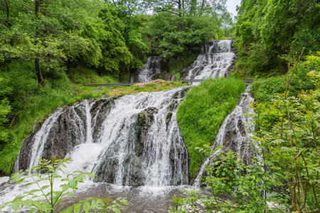 Upper and bottom cascades of the Dzhurynskyi, or Chervonohorodskyi waterfall on Dzhuryn river in spring overcast day, Ukraine, bottom view close-upの写真素材
