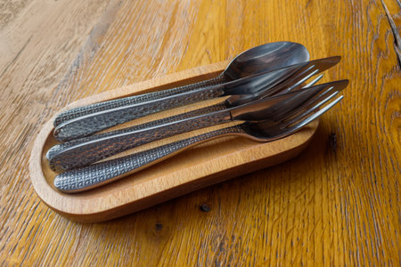 Set of stainless steel eating utensils consisting of spoons, forks and knives on the special serving...