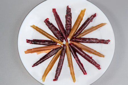 Thin soft flexible pastila made with dried puree of different red fruits and berries and rolled into...