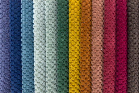 Narrow strips of soft textile different colors stacked next to each other and forming a color...