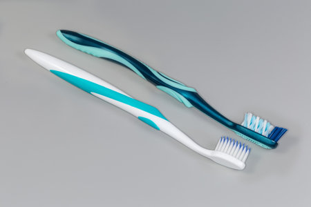Two different modern traditional toothbrushes, one with elastic bristles with soft tops and other...