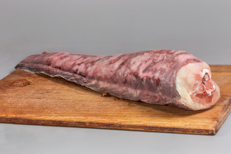 Carcass of kingklip, also known as pink cusk-eel without head and tail on an old wooden cutting board, side view close-up on a gray backgroundの写真素材