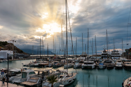 Small sea harbour with moored different boats and yachts and their reflection in calm water against...