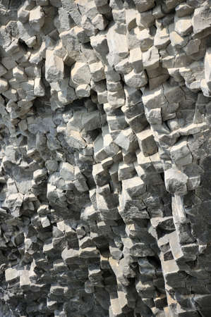 Gray textured lava rocks wall in daylight