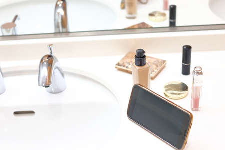 Make-up on the wash surface Liquid foundation, lipstick, smartphoneの写真素材
