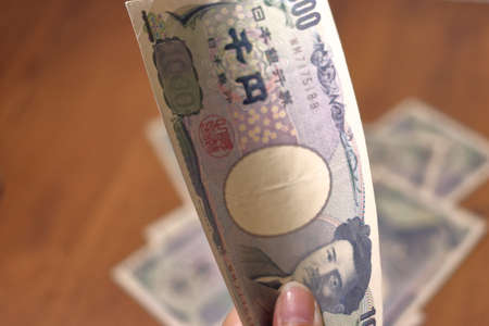 A hand that holds Japanese money (1,000 yen bill)