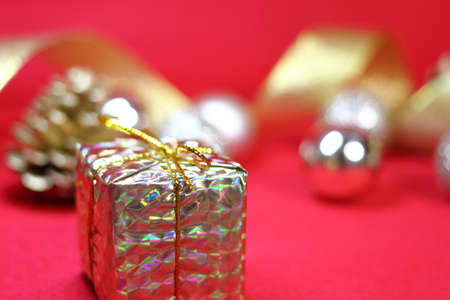 Gift box and golden decoration (red background)の写真素材