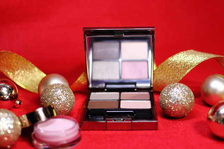Colorful decoration with eyeshadow and highlight cream cosmetics (red background)の写真素材