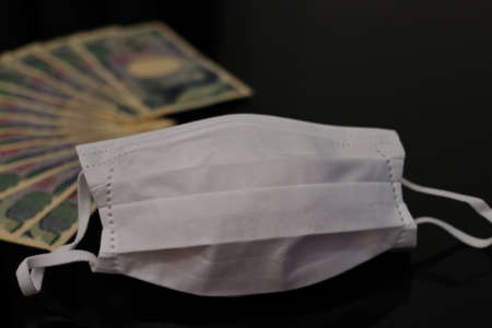 Japanese money and white mask placed on the table