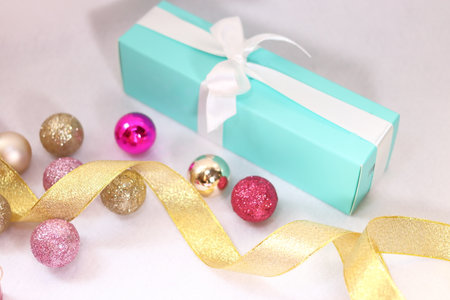 Gift box with pink and gold colorful decoration and white ribbon (white background)の写真素材