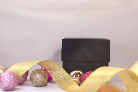 Black gift box with pink and gold colorful decoration (white background)