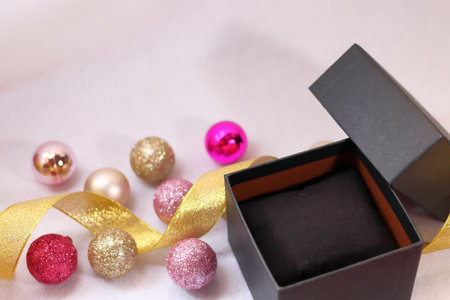 Black gift box with pink and gold colorful decoration (white background)