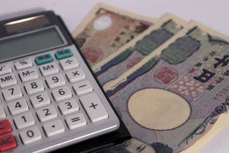 Japanese money on white background (bills and calculators)の写真素材