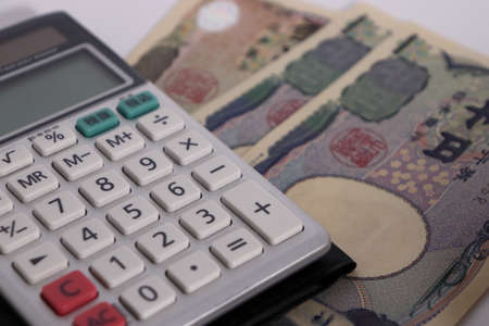 Japanese money on white background (bills and calculators)の写真素材