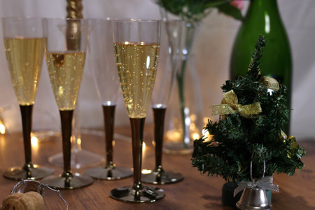 Image of a party with champagne and champagne bottles and roses on the tableの写真素材