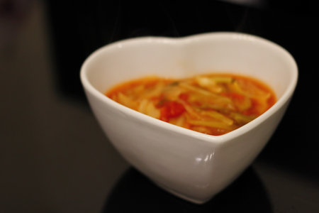 Healthy vegetable soup in a bowl of white heartsの写真素材