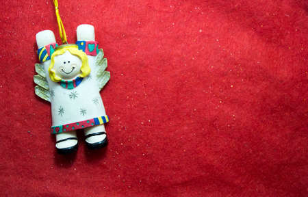 Decoration of gypsum christmas angel on red background