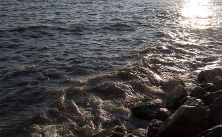 Lumpy sea and rocks on sunset. Lumpy sea at cloudy day
