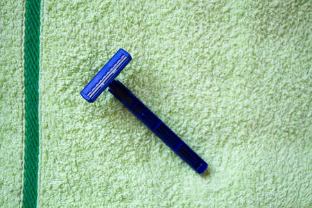 Blue blade over fresh green towel background close-upの写真素材