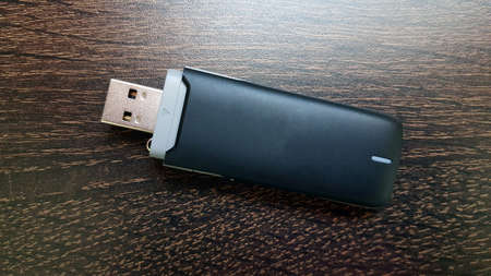 Black 3g usb wireless mobile modem on wooden backgroundの写真素材