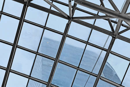 Fragment of  glass ceiling in rainy weather. Blur wall of  adjacent higher buildings and sky are visible. Background. Texture.の写真素材