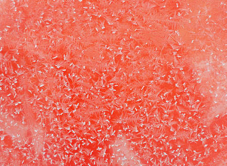 Hoarfrost on a smooth red metal surface.