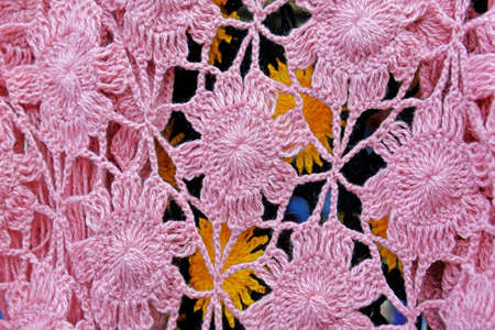 Fragment of pink wool openwork shawl knitted by handmade shawl. Background. Texture.