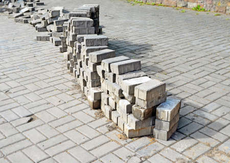 Repair pavement on street or square.
Long stack of disassembled paving tiles crosses image diagonally. Background.の写真素材