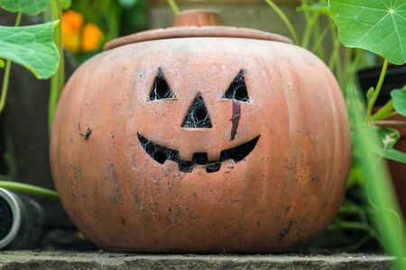 Ceramic Halloween lantern in a garden with spiderwebs formed in the holesの写真素材