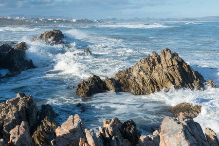 Waves crash on rocks in the fishing village of Kleinbaai, near Gansbaai, South Africaの写真素材