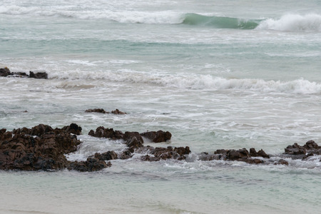 Rolling waves on the shoreline of a beach in Gaansbaai, South Africaの写真素材