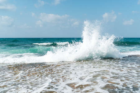 Waves on the beach on a bright sunny dayの写真素材