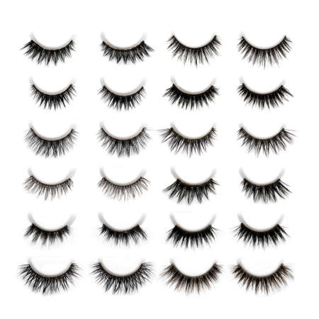 A set of 10 different types of black long dramatic false eyelashes symmetrically arranged on white...
