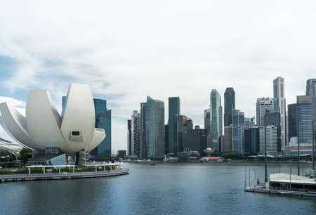 Singapore - June 6 2017: ArtScience Museum at Marina Bay and Central Business District (CBD) skyline with few people on the embankment in natural light, daytimeのeditorial素材