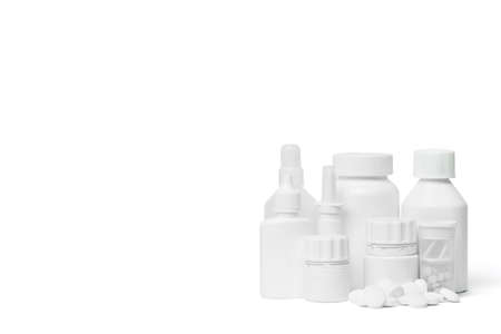Multiple white clean medical bottles and a stack of white round pills on white background shot with studio lightの写真素材