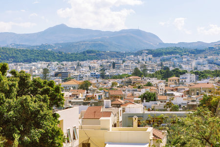 View of resort Greek architecture Rethymno city-port, built by Venetians, from height of Fortezza Castle - fortress on hill Paleokastro. Red tiled roofs and mountains in background. Crete, Greeceの写真素材