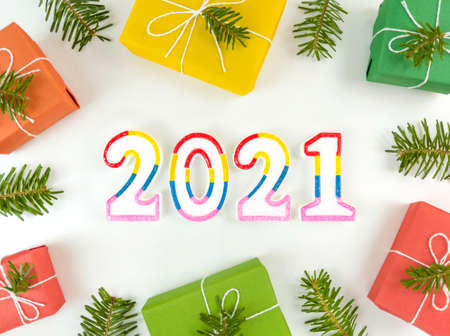 Holiday postcard with fir tree branches, gift boxes, and 2021 figures on white background. Christmas flat lay.の写真素材
