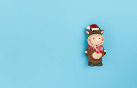 Ceramic statuette of Ox on blue paper. Symbol of new year 2021. Simple flat lay with copy space.