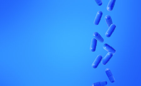 Blue capsules falling, blue background, medical visual concept, copy spaceの写真素材