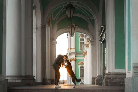 a girl and a dog on the background architecture St. Petersburg. Traveling with pet in the cityの写真素材
