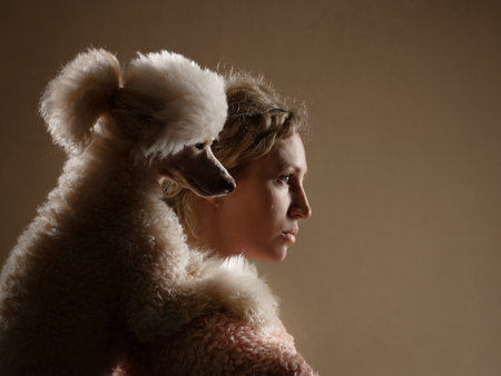 happy girl with a dog in a photo studio on black. white Poodle and curly womanの写真素材
