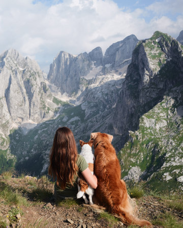 girl and two dogs in the mountains. Traveling with a pet, adventure animal. Hiking in the peaks of Montenegro, Albaniaの写真素材
