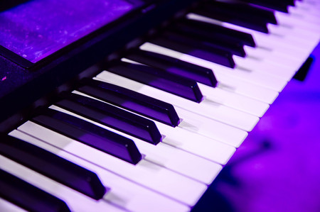 piano keys close up in purple concert lightの写真素材