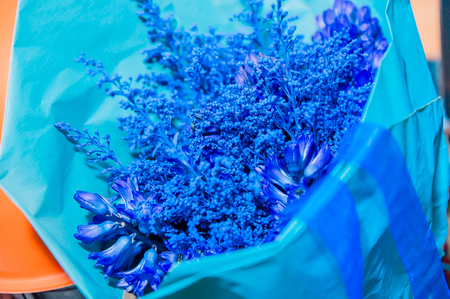 bouquet of blue flowers in blue paperの写真素材