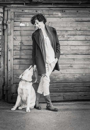 an elegant girl and a labrador retriever dog looking at each other