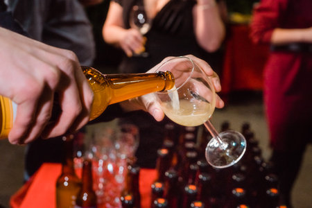 the pouring of fruit cider into a glass at a partyの写真素材